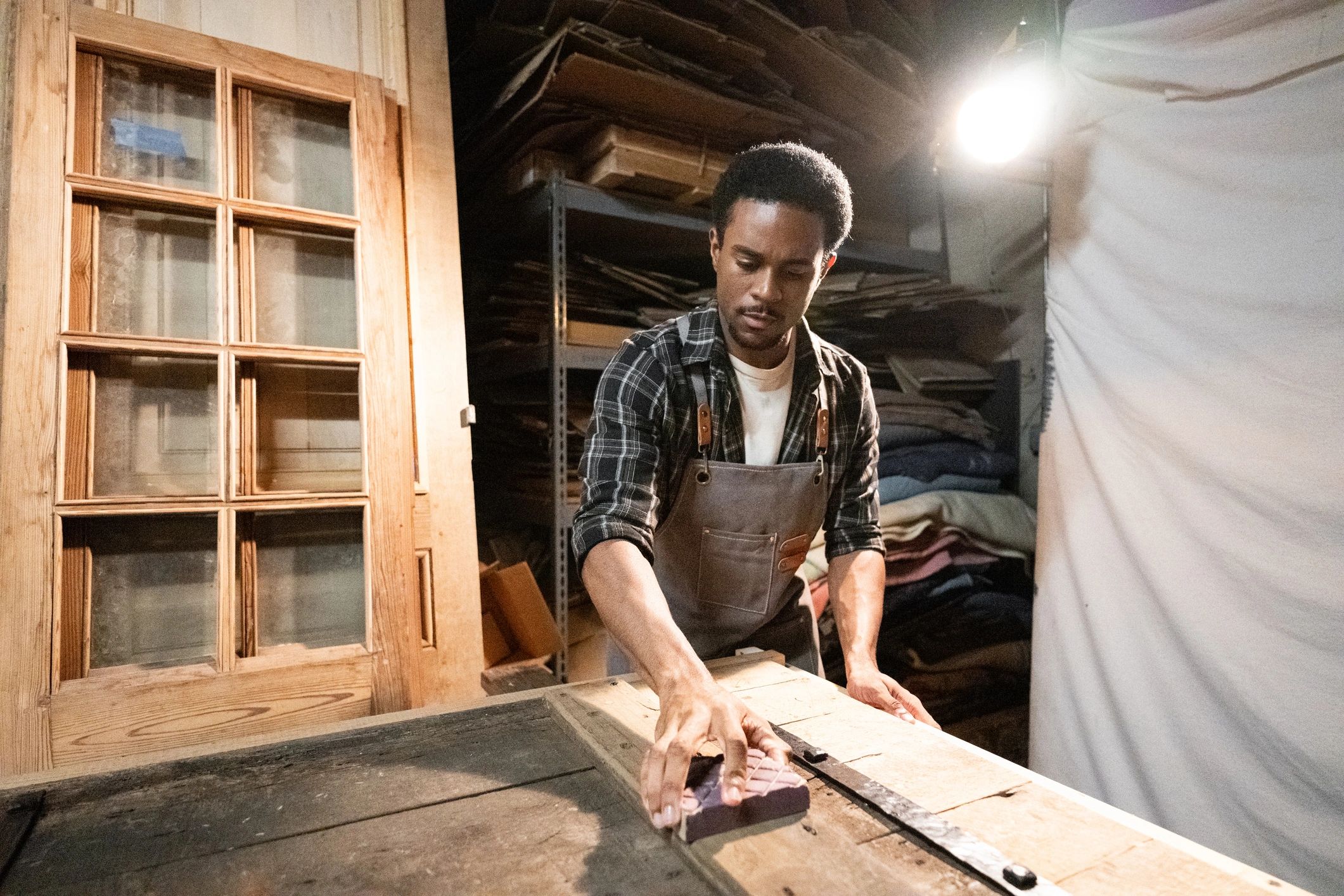 Carpenter restoring a wooden door in a workshop