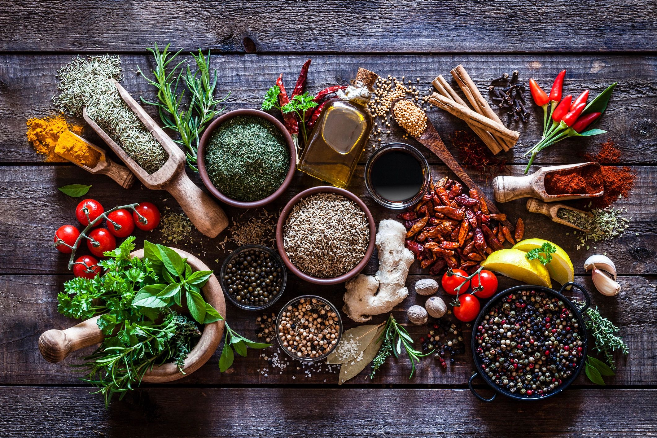 Spices and herbs arranged on a rustic wooden table
